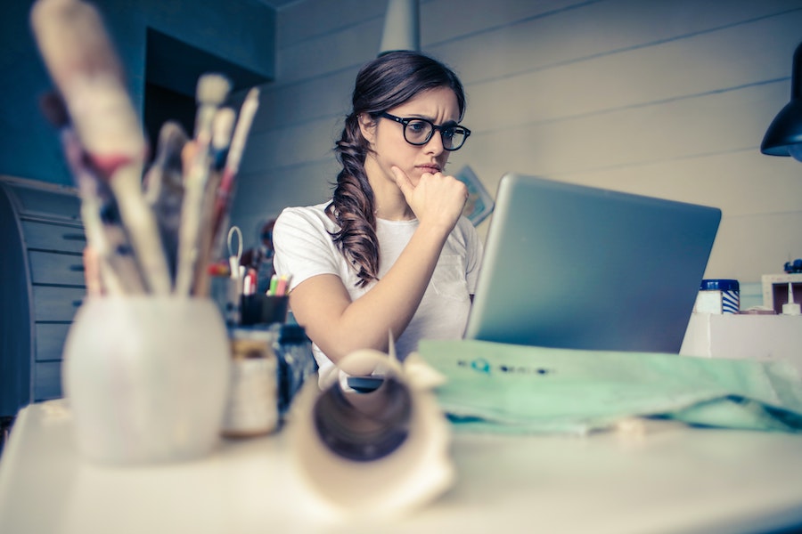 woman with dream job at home in front of laptop thinking